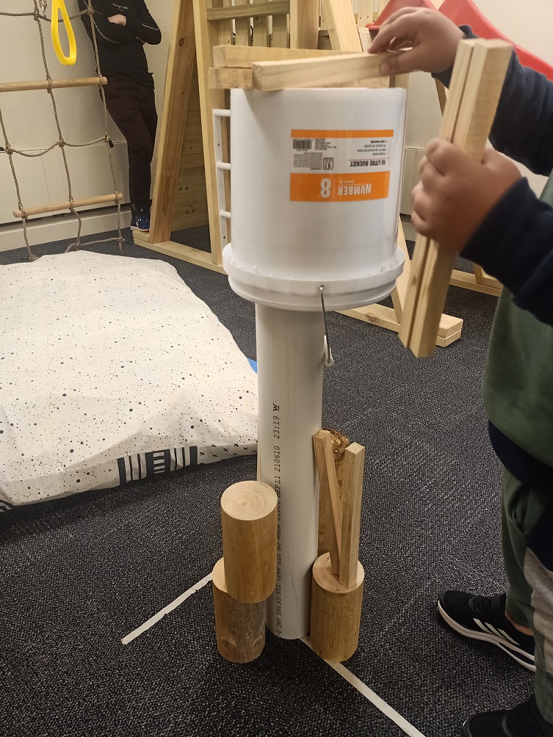 child making a tower with spare parts