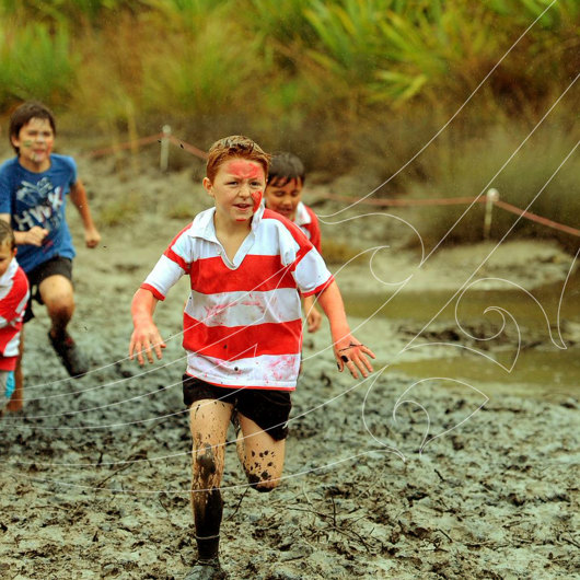 Boys running on a very muddy track