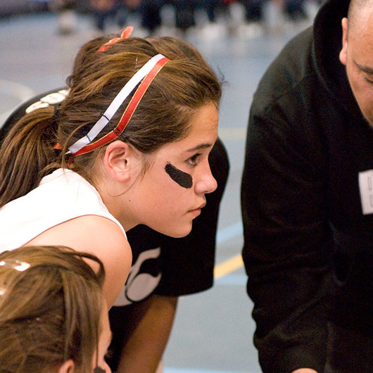 Female basketball team listening to their coach