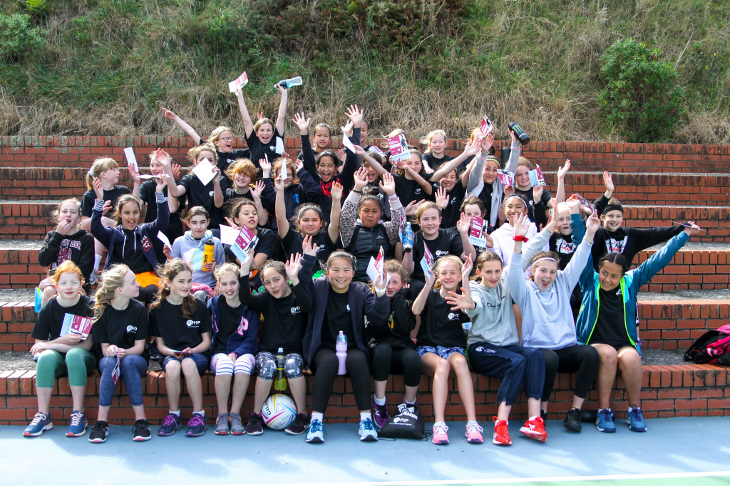 group of young girls with their hands in the air celebrating