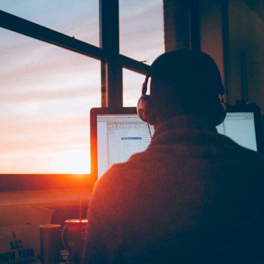 Man sitting at a computer with headphones