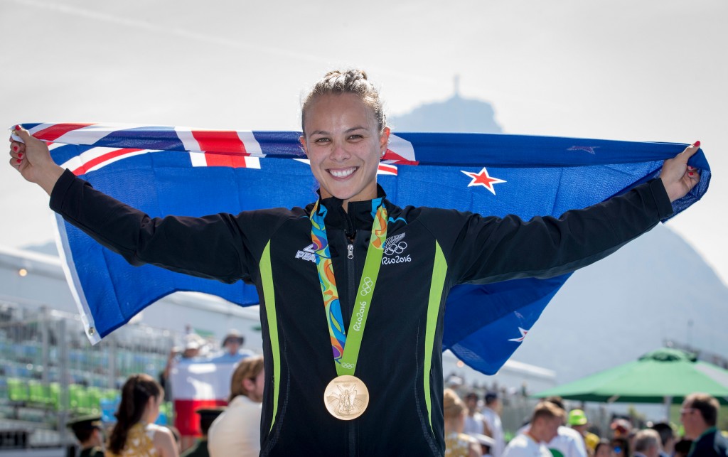 Lisa Carrington at the Olympics holding a flag behind her