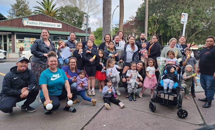 Group of people including tamariki looking at the camera