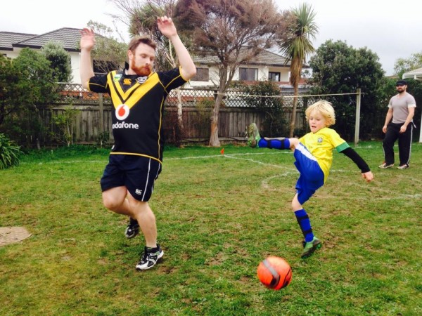 Father and son playing football in their backyard