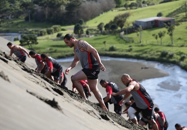 Men doing exercise on a sand dune