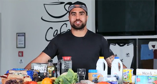 Man standing behind a range of healthy foods on a bench