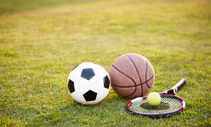 Football soccer ball basketball tennis ball and racket laid