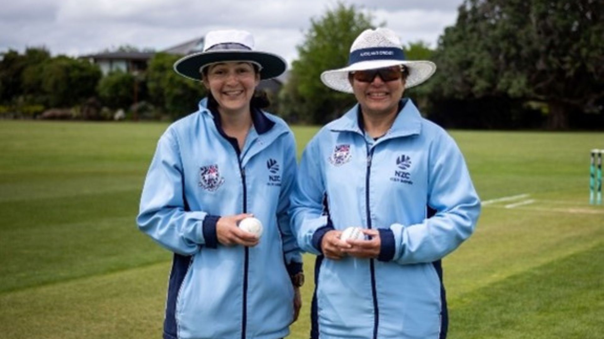 Two women holding cricket balls