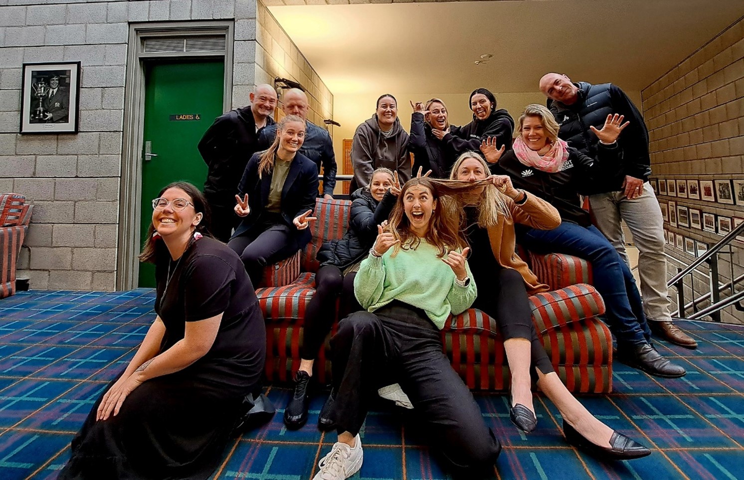 Group of people sitting on and around a couch