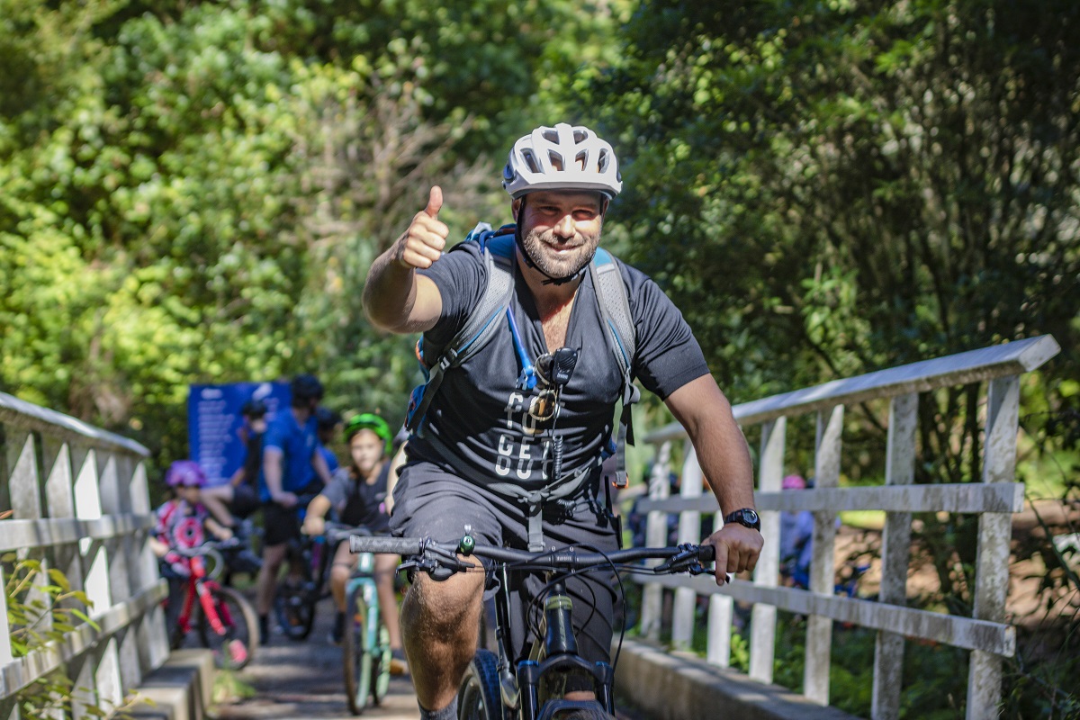 man on a bike giving the thumbs up