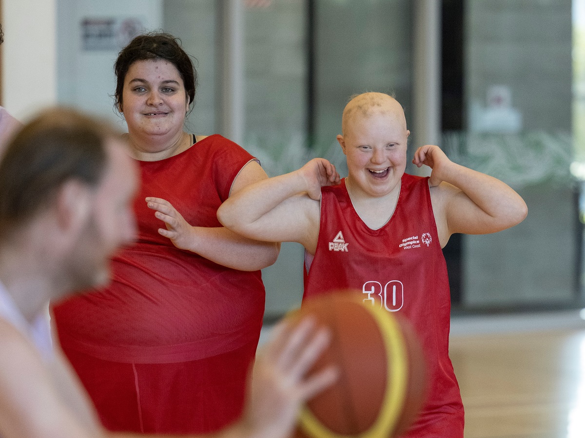 Two rangatahi in basketball shirts looking to camera