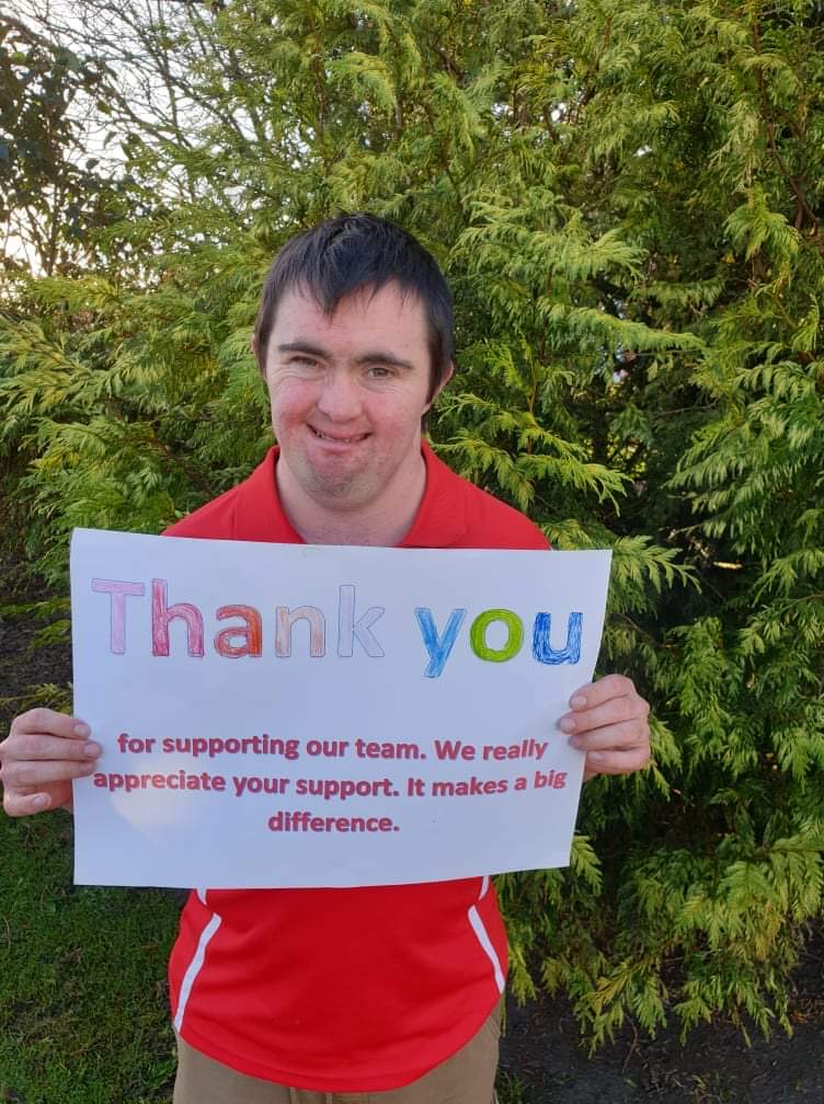 Young person holding up a thank you sign