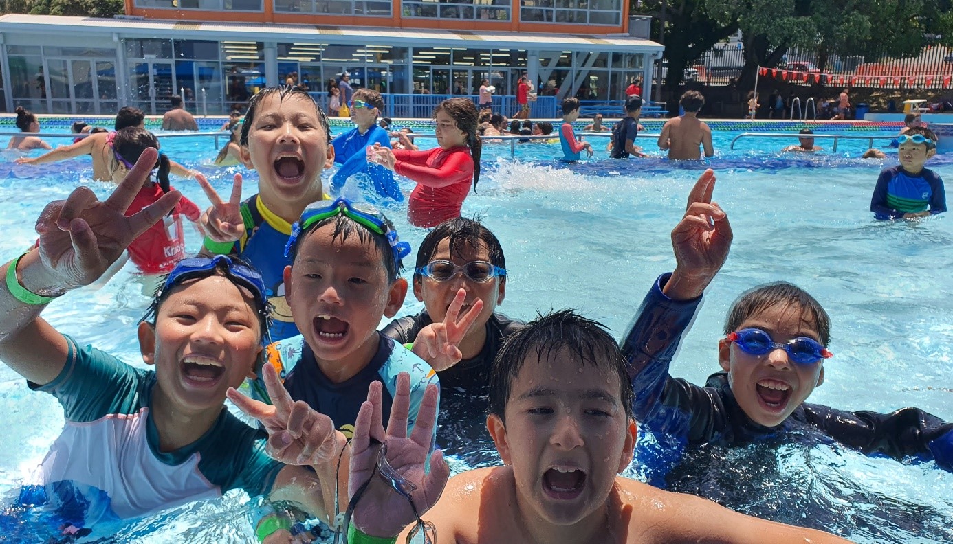 Group of 6 young people having fun in a pool