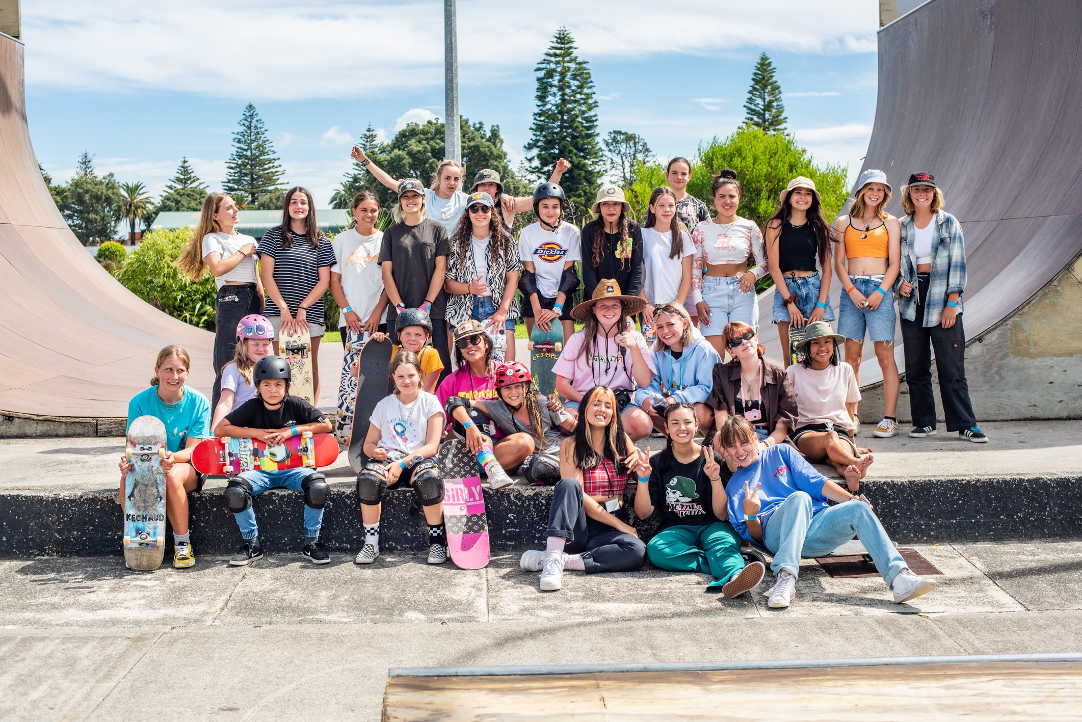 group of young women sitting near a skate ramp