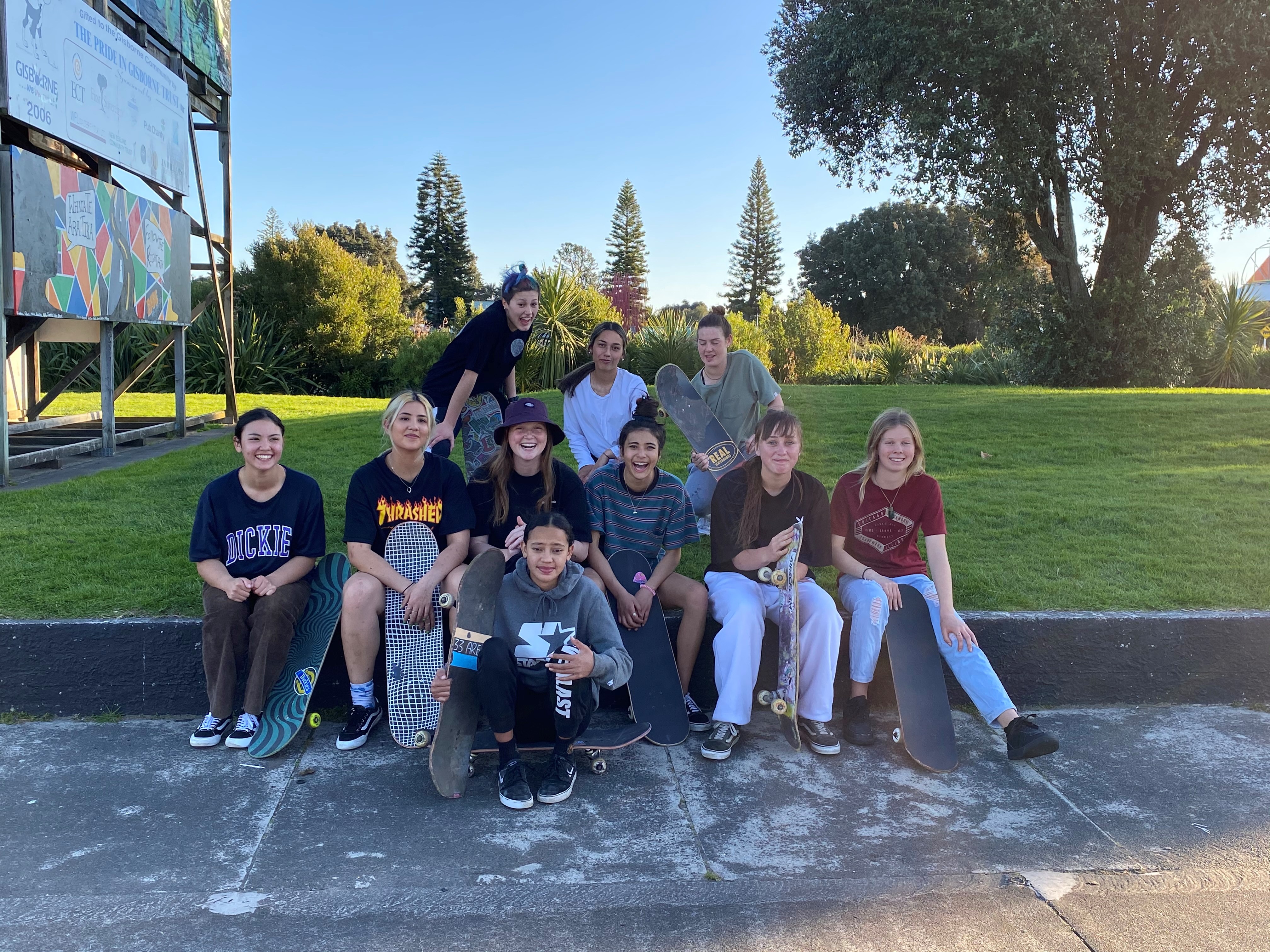 Group of young women skateboarders smiling at camera