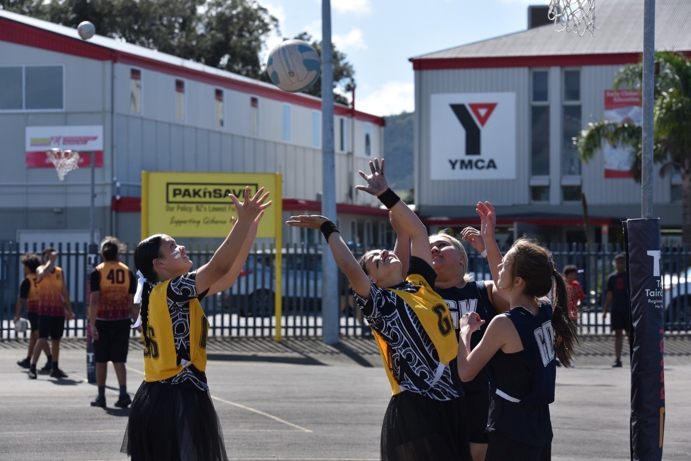 Young women playing netball on a ymca court