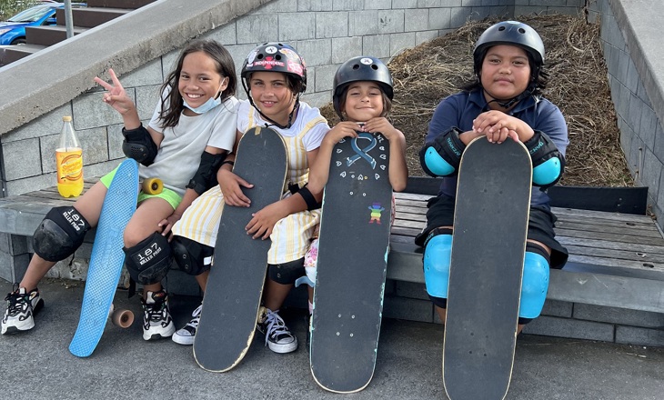 Four tamariki holding skateboards