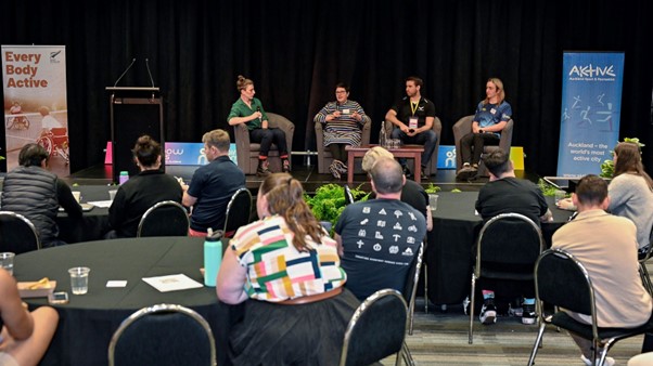 Four people on a panel on stage at the Rainbow Games