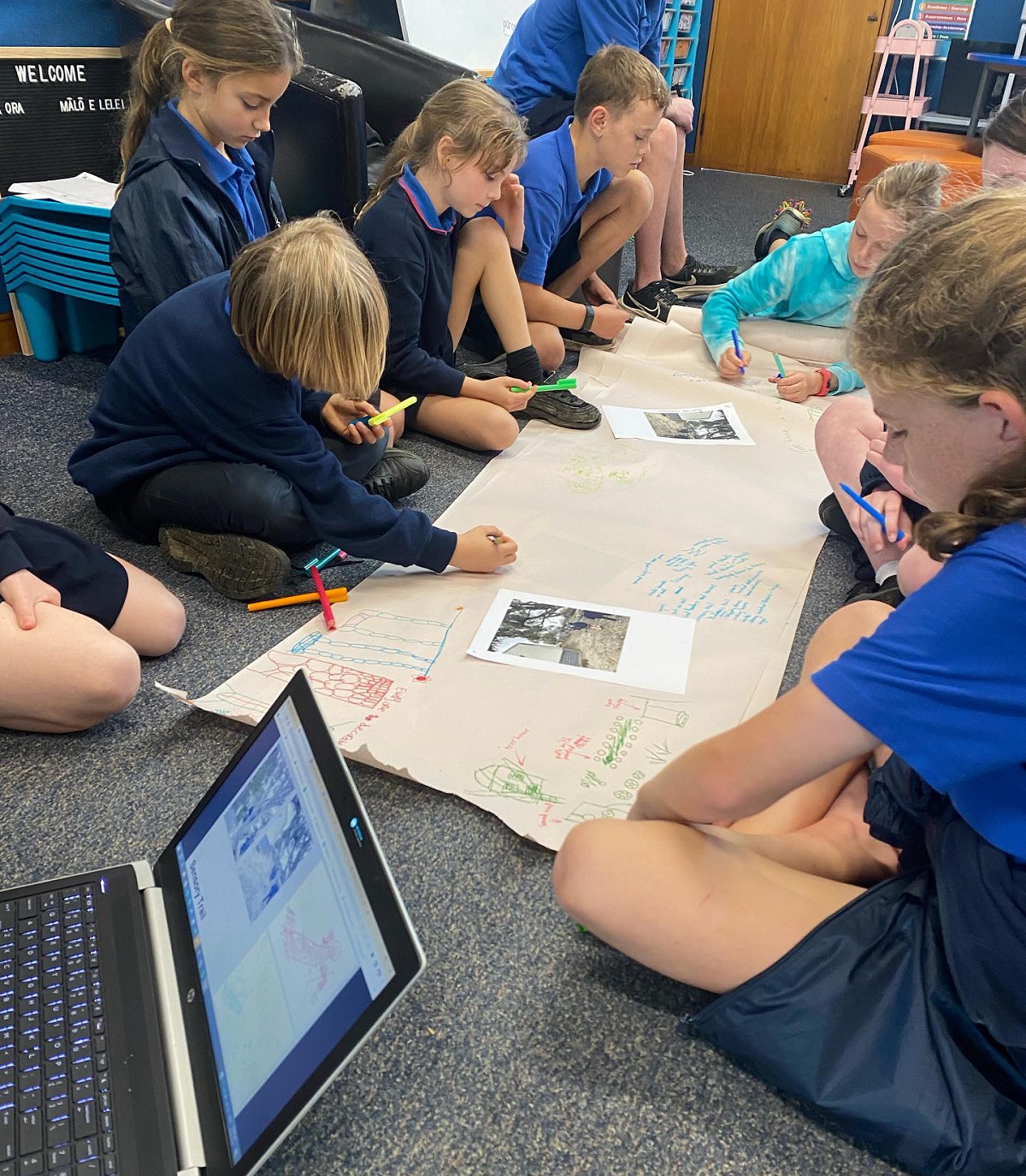 Kids in a classroom setting working on butchers paper