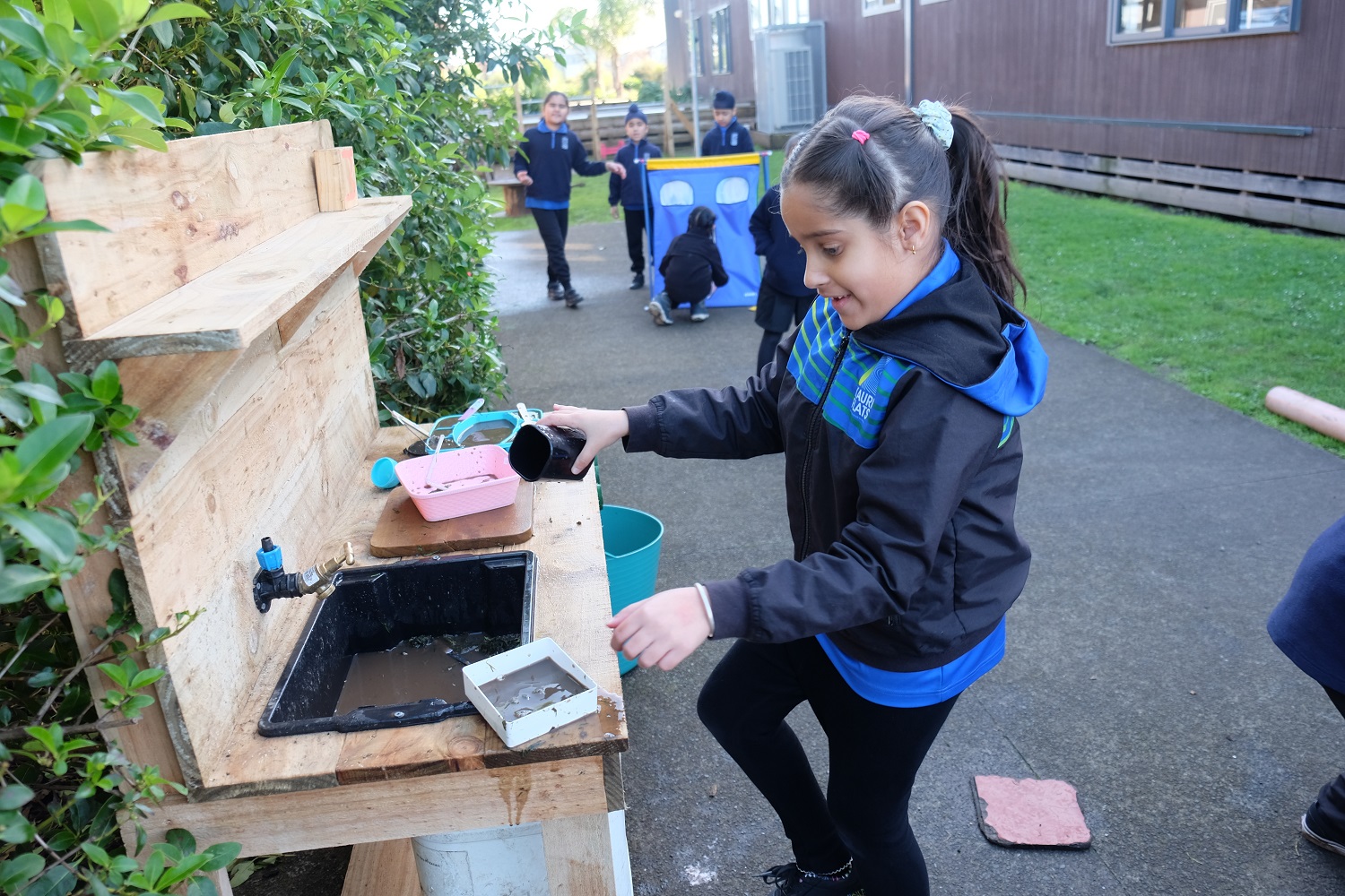 child playing at a mud kitchen