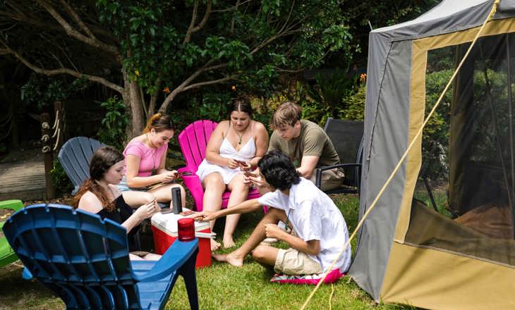 Group of rangatahi looking at their phones