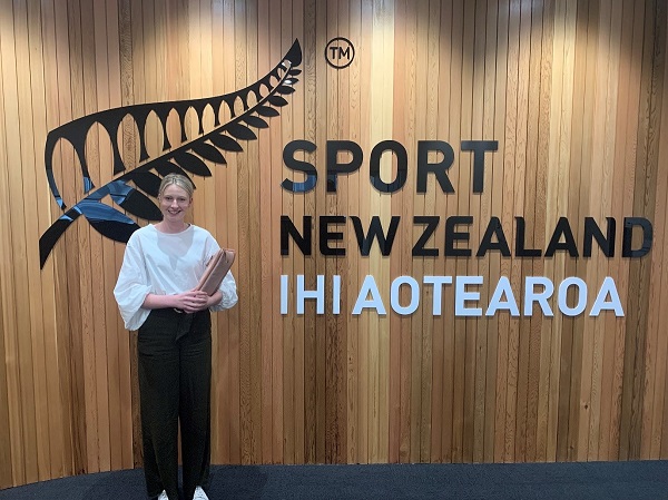 Libby Davenport standing in front of the Sport New Zealand sign