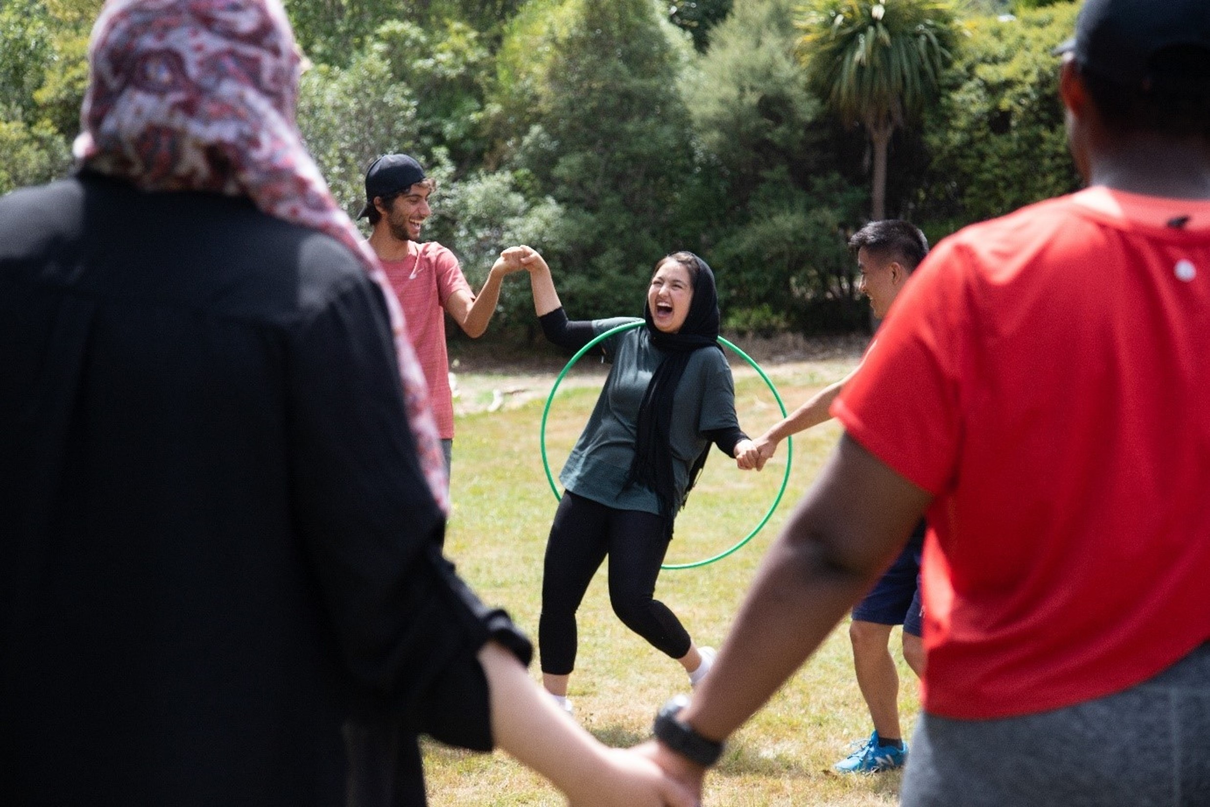 Rangatahi participating in a group activity with a hula hoop