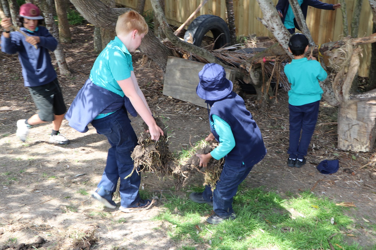 Kids playing with spare parts to make a fort in a park