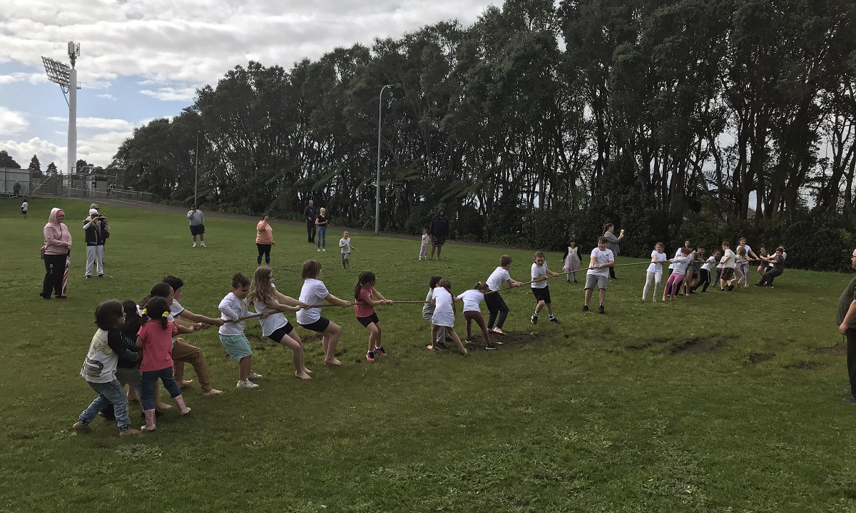 Kids playing tug of war on a field