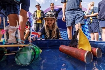 girl looking over toy yachts