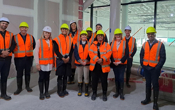 group of people standing in a construction site wearing hard hats and high vis