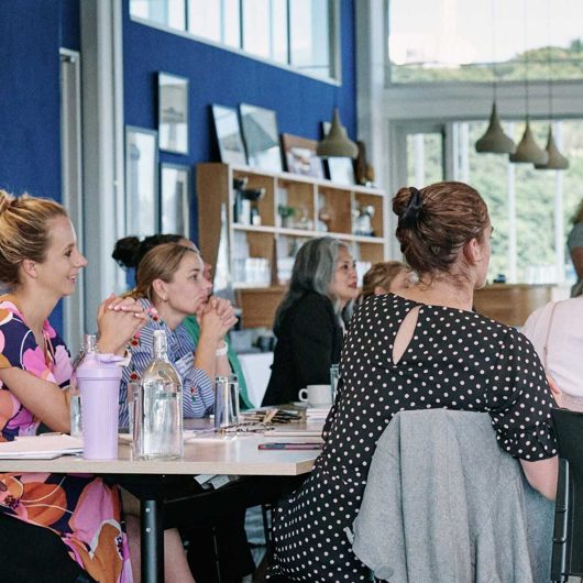 Group of people at a hui looking off camera